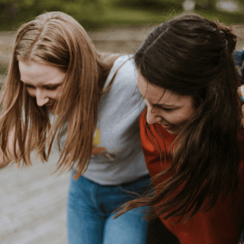 Två tjejer som håller om varandra och går.